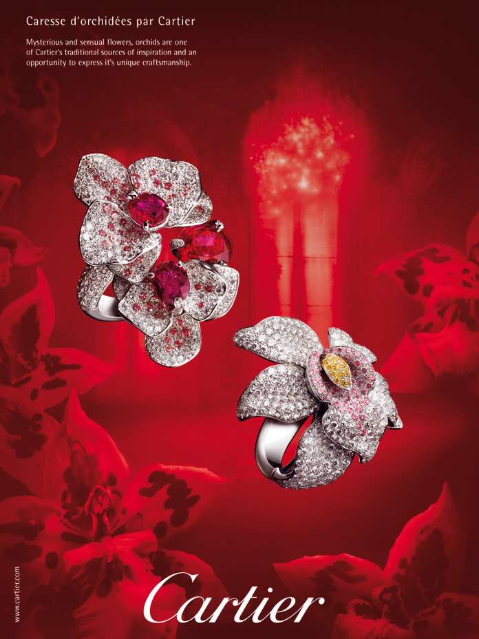2 bagues en forme d'orchidées diamant et rubis devant une composition monochromes rouge d'intérieur luxe avec des fleurs